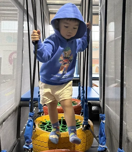 Child playing on the indoor play frame